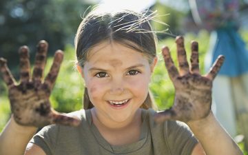 Image of a girl holding her dirty hands towards the camera