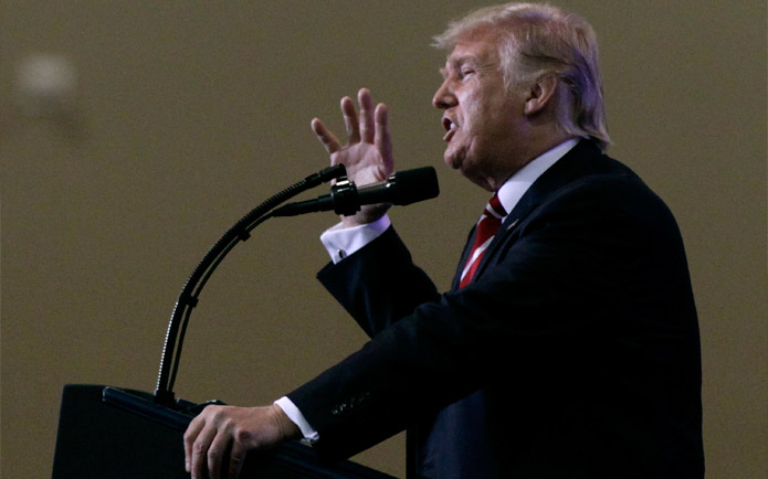 An image of Donald Trump speaking and gesturing into a microphone
