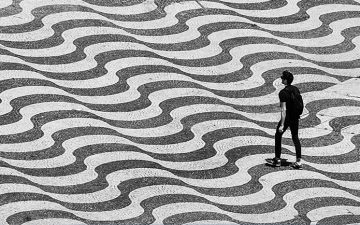 Black and white image of a man walking on a street with wavy lines