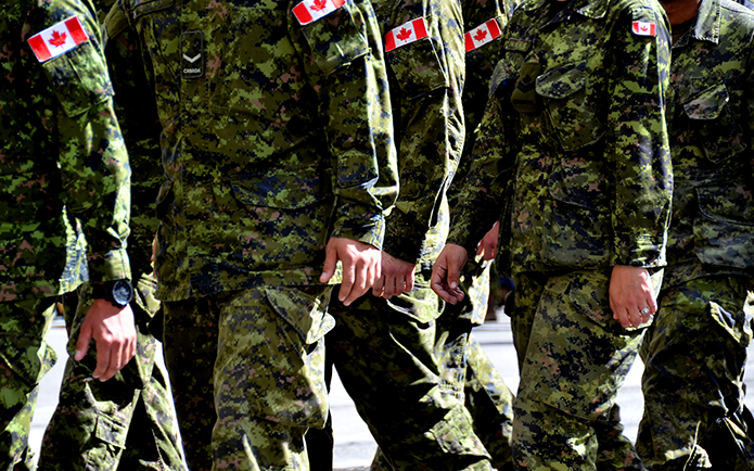 Image of Canadian soldiers wearing green camouflage marching together