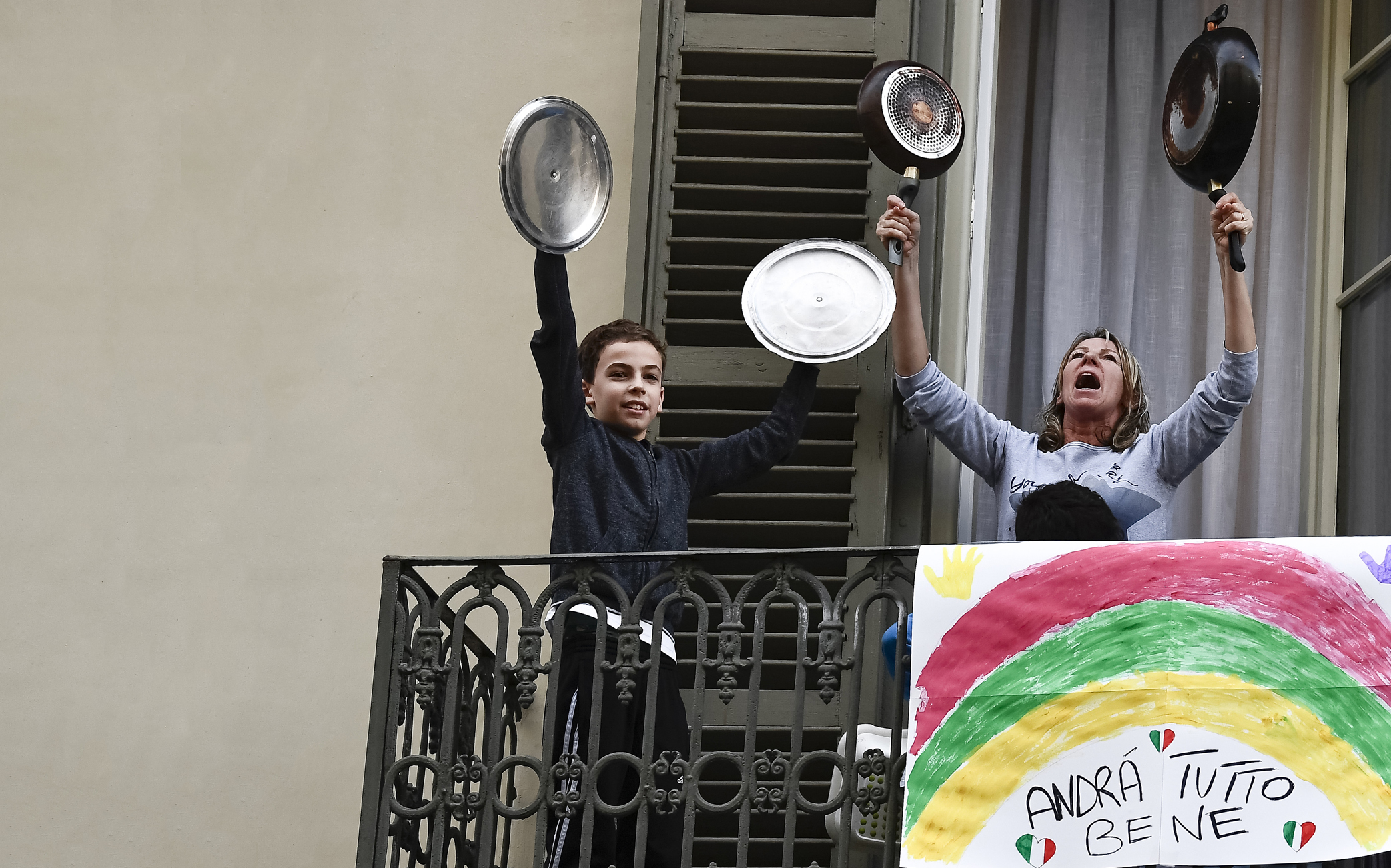 image of a woman and a boy holding pans up in the air